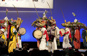 Colorful costumes and a variety of musical instruments create a dramatic stage presentation.
