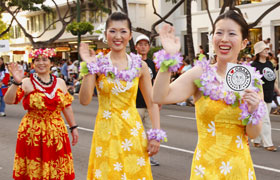 The Obama Girls wave to the crowd carrying a sticker of Obama.