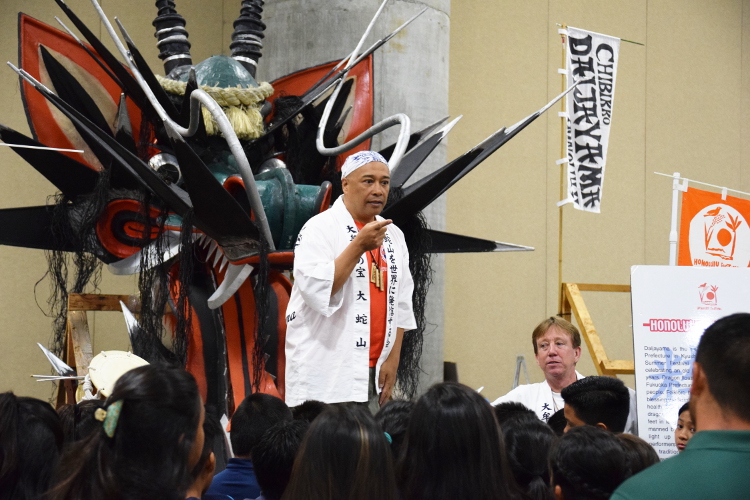 毎年、最終日のグランドパレードでオオトリを務める大蛇山。頭部のみでもその迫力たるや学生や子供たちに興味を持たせずにはいられません。 火を吹く大蛇(ホノルル大蛇山を支援し、大蛇山を世界に発信する会)は福岡県大牟田市からやってきました。民話によると大蛇は農地を潤し、子供の健康を守る水の神と言われています。